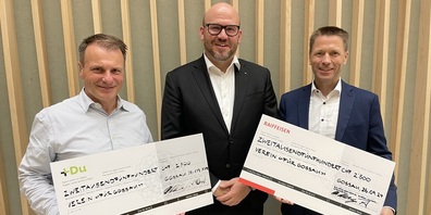 Verwaltungratspräsident Patrik Forster (links) und Bankleiter Marcel Helfenberger (rechts) übergeben die symbolischen Spendenschecks an Pater Andy Givel.