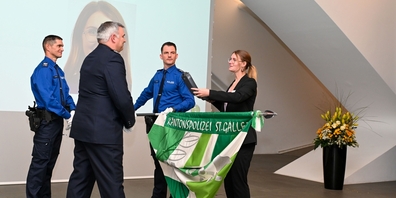 Eine Aspirantin (1.v.r.) hat von Christian Aldrey (2.v.l.), Kommandant ad interim der Kantonspolizei St.Gallen, ihre persönliche Dienstwaffe erhalten.