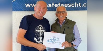 (v.l.) Cony Sutter vom OK Hafefäscht bei der Preisübergabe an Louis Freuler, dem neu gezogenen Gewinner eines Weekends in Saas-Almagell.