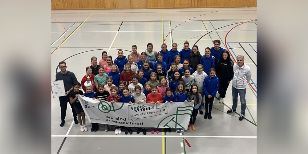 Gruppenfoto der Flying Penguins: Die Vereinsmitglieder posieren stolz mit dem Banner von Sport-verein-t.