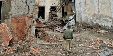 Ein Mann geht durch ein zerstörtes Gebäude in Tschernihiw, Oblast Tschernihiw, Ukraine.