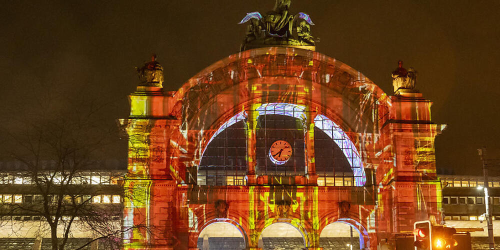 Die Lichtprojektion "Do Humans need Humans ?" erleuchtet den Torbogen des Luzerner Bahnhofs.