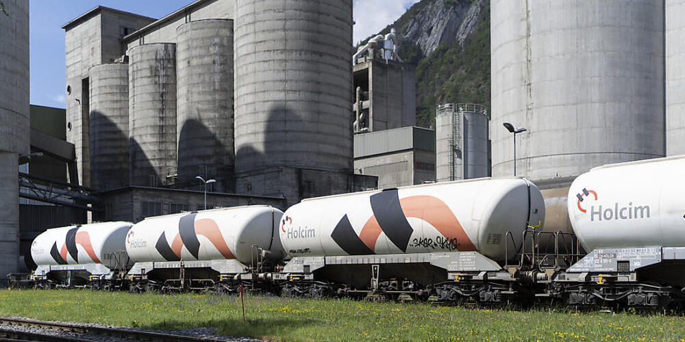 Ein Güterzug steht vor Silos des Holcim Zementwerks in Untervaz im Bündner Rheital. Die Industrie ist in der Region für 63 Prozent des CO2-Ausstosses verantwortlich. (Archivbild)
