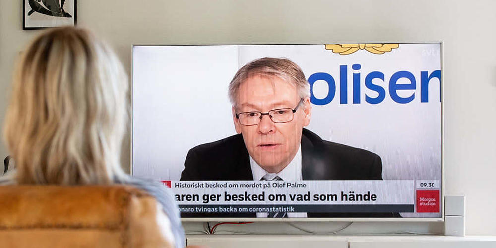 Eine Frau schaut die Pressekonferenz von Krister Peterson, Chefankläger im Fall der Ermordung des ehemaligen schwedischen Ministerpräsidenten Olof Palme. Foto: Daniel Stiller/Bildbyran via ZUMA Press/dpa