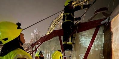Feuerwehrleute befreien das Zeltdach von den Schneemassen.