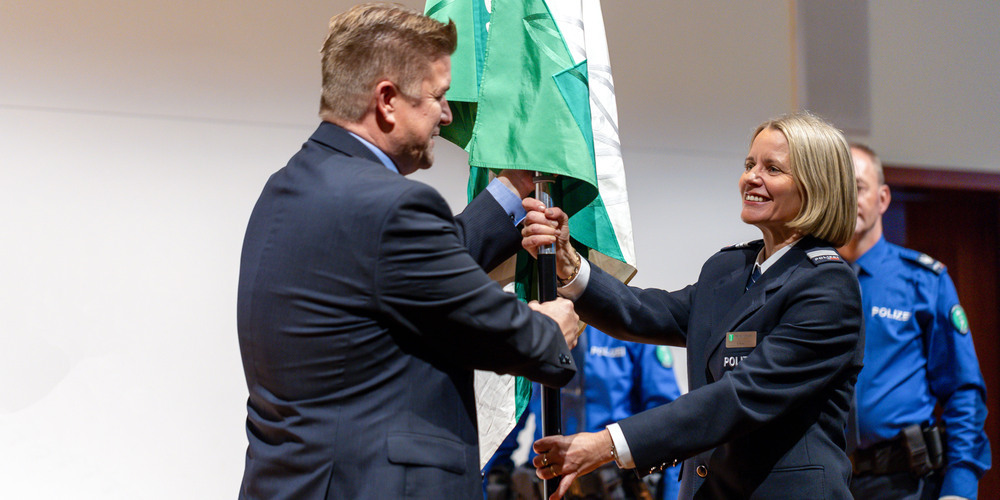 Regierungsrat Christof Hartmann (l.) übergibt Barbara Reifler die Fahne der Kantonspolizei St.Gallen.