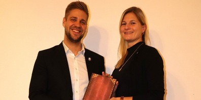 Katja Kraemer übergibt Aaron Ulmann feierlich das Präsidentenbuch.
