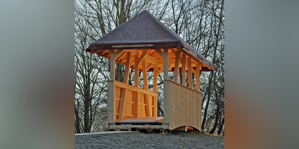 Die überdachte Fussgängerbrücke steht imposant auf einer kleinen Anhöhe.