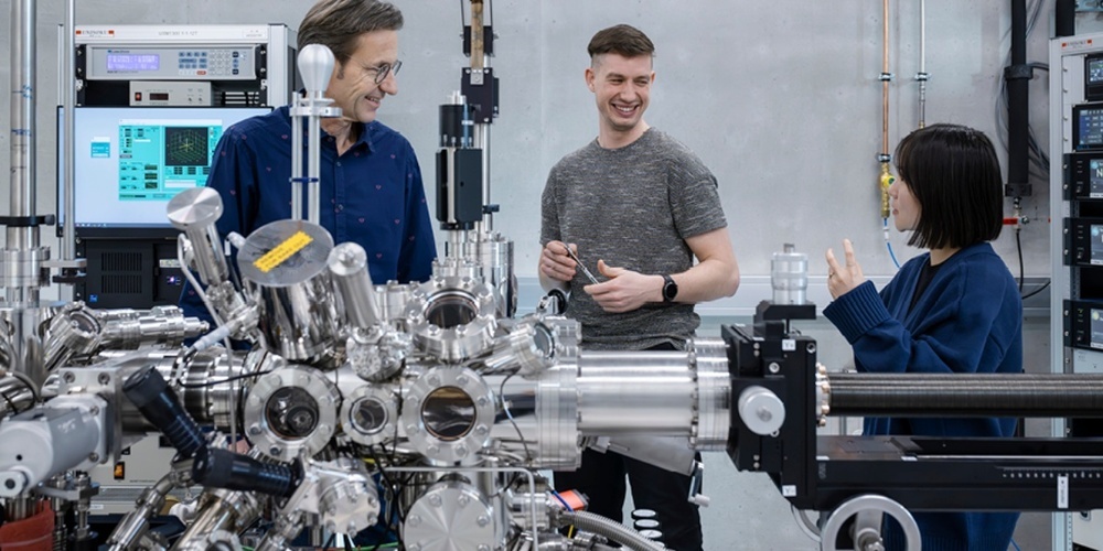 Empa-Forschende Roman Fasel, Stepan Kovarik und Yujeong Bae mit einem der neuen Rastertunnelmikroskope. Mit seinem grossen unterirdischen Helium-Tank und dem starken Magnetfeld stellte das Gerät hohe bauliche Anforderungen, die im neuen Laborgebäude der Empa auf dem Campus «co-operate» erfüllt werden konnten. 