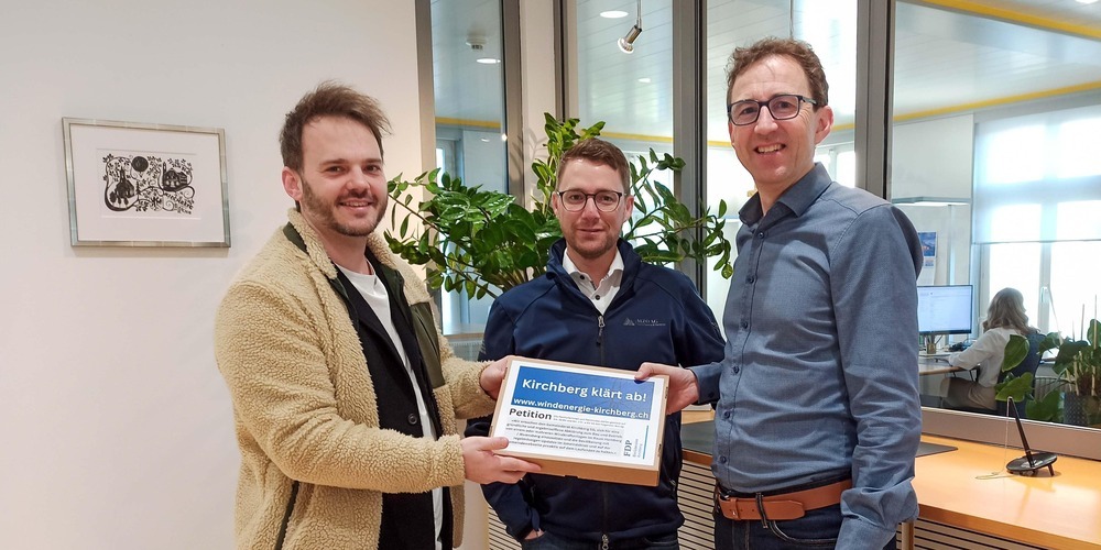 Remo Sprecher und Simon Seelhofer übergeben Gemeindepräsident Roman Habrik die Petition «Kirchberg klärt ab!».