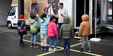 Dave Gooljar erklärt den Kindern, wie ein Langstock eingesetzt wird.
