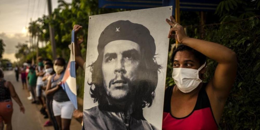 Frau in Havanna wartet während der Corona-Krise auf die Mediziner-Brigade des Henry Reeve Contingent und hält dazu das ikonische Foto "Guerillero Heroico" von Che Guevara hoch, das offenbar für jeden Anlass passt. Die Wohnung, in der Che geboren w...