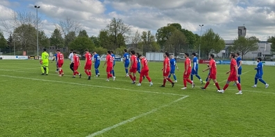 Die Spieler des FC Uznach (rote Trikots) und des FC Münchwilen (blaue Trikots) laufen auf der Sportanlage Waldegg in Münchwilen TG ein.