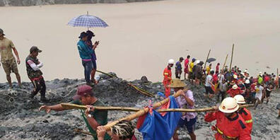HANDOUT - Rettungskräfte sind nach einem Erdrutsch in einem Jade-Bergwerk in Myanmar im Einsatz. Mindestens 110 Arbeiter sind daei gestorben. Foto: Feuerwehr Myanmar/dpa - ACHTUNG: Nur zur redaktionellen Verwendung im Zusammenhang mit der aktuelle...