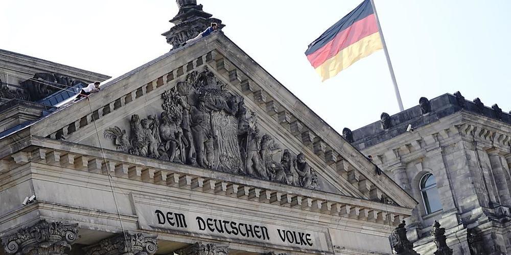 Greenpeace-Aktivisten seilen sich mit einem Transparent vom Reichstagsgebäude ab, auf dem geschrieben steht: «Eine Zukunft ohne Kohlekraft». Der Bundestag verabschiedet heute ein neues Kohlegesetz. Foto: Kay Nietfeld/dpa