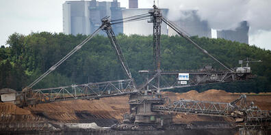 Hinter dem Schaufelradbagger 255 im Braunkohletagebau Inden kommt Dampf aus den Kühltürmen des Braunkohlekraftwerks Weisweiler. Bundestag und Bundesrat haben den schrittweisen Kohleausstieg in Deutschland bis spätestens 2038 beschlossen. Foto: Fed...
