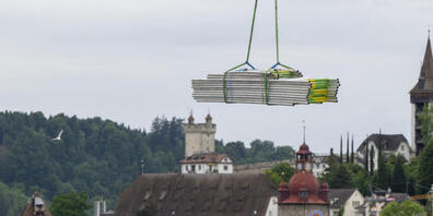 Die Baumaterialien für eine neue Photovoltaikanlage auf dem Dach der KKL in Luzern werden mit einem Helikopter transportiert.