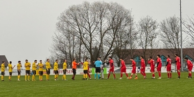 Die Spieler des FC Kirchberg (gelbe Trikots), der Schiedsrichter und die Spieler des FC Uznach (rote Trikots) beim Handschlag.