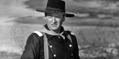 ARCHIV - John Wayne während der Dreharbeiten zu dem Film «Der letzte Befehl» (Originaltitel: «The Horse Soldiers»). Foto: -/AP/dpa