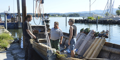 Die Holz-Skulpturen von Daniel Eggli (l.) wurden auf ein Schiff verladen und zur Insel transportiert.