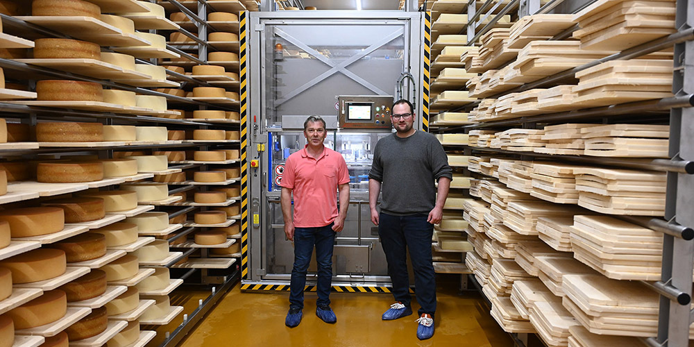 Geschäftsinhaber Erich Keller (l.) und Geschäftsführer Tobias Züger vor dem Käseroboter. 