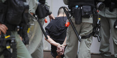 Die Polizei hält einen Demonstranten fest, der am 23. Jahrestag der Rückgabe Hongkongs an China am Causeway Bay protestiert. Foto: Kin Cheung/AP/dpa