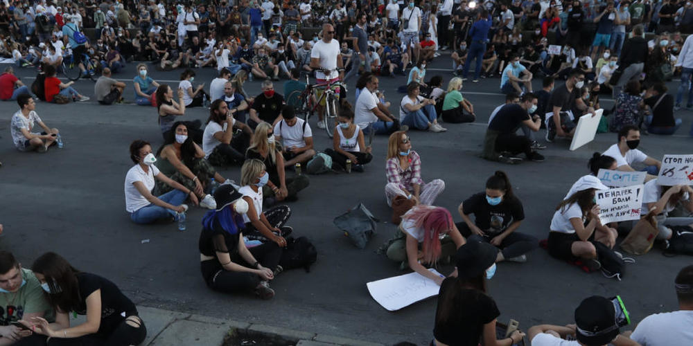 Demonstranten in Belgrad protestieren sitzend gegen die von Präsident Aleksandar Vucic verhängten Corona-Restriktionen. (Foto: Darko Vojinovic/AP/KEYSTONE-SDA)