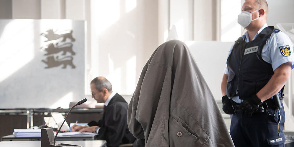 dpatopbilder - Der Angeklagte (M) im Prozess um einen sechsfachen Mord in Rot am See sitzt in einem Saal des Landgerichts mit einer Jacke über seinem Kopf an seinem Platz, hinter ihm sitzt sein Verteidiger Andreas Kugel (l). Der junge Mann soll En...