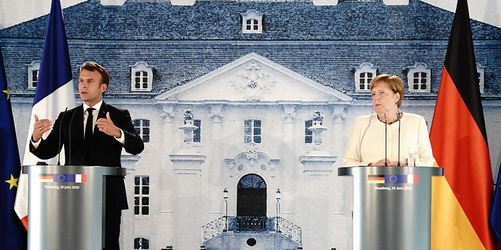 Bundeskanzlerin Angela Merkel und Frankreichs Präsident Emmanuel Macron sprechen nach ihrem Treffen im Schloss Meseberg in Brandenburg. Foto: Kay Nietfeld/dpa-Pool/dpa