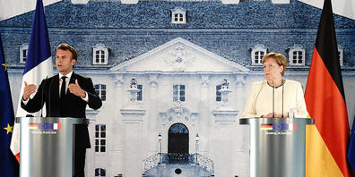 Bundeskanzlerin Angela Merkel und Frankreichs Präsident Emmanuel Macron sprechen nach ihrem Treffen im Schloss Meseberg in Brandenburg. Foto: Kay Nietfeld/dpa-Pool/dpa