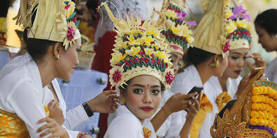 ARCHIV - Tänzerinnen und Tänzer in traditioneller Kleidung in einem Hindu-Tempel auf Bali. Foto: Firdia Lisnawati/AP/dpa