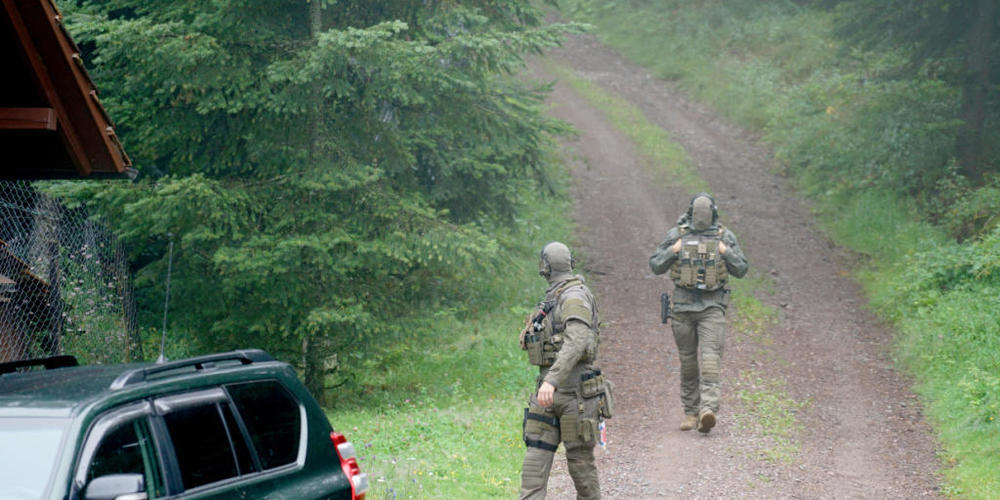 Polizisten gehen bei Oppenau durch ein Waldgebiet.) Foto: Benedikt Spether/dpa