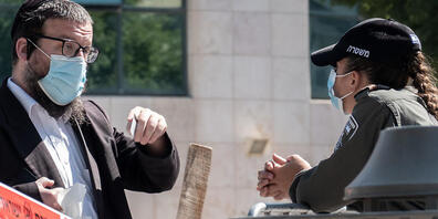 Eine Polizistin prüft den Ausweis eines jüdischen Anwohners in Jerusalem. Die israelische Regierung führt erneut Lockdown-Maßnahmen ein. Foto: Nir Alon/ZUMA Wire/dpa