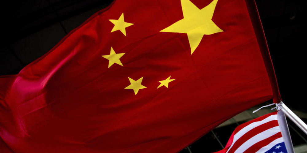 ARCHIV - Die US-amerikanische (unten) und chinesische Nationalflaggen wehen vor einem Hotel. (zu dpa «China: USA fordern Schließung des chinesischen Konsulats in Houston») Foto: Andy Wong/AP/dpa