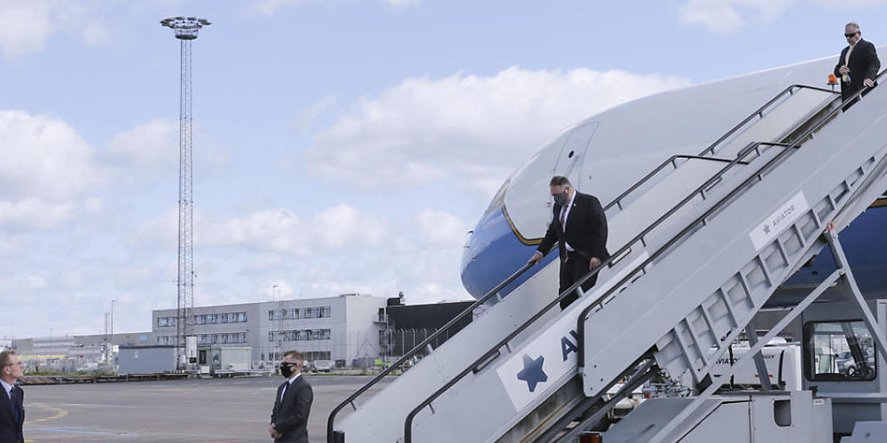 Mike Pompeo, Außenminister der USA, trägt einen Mund-Nasenschutz, während er nach seiner Landung aus der Maschine steigt und von Carla Sands (l), US-Botschafterin in Dänemark, begrüßt wird. Foto: Thibault Savary/pool AFP/AP/dpa