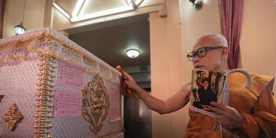 Ein buddhistischer Mönch betet am Sarg des verurteilten Serienmörders Si Ouey, bevor er im Wat Bang Phraek Tai-Tempel in Thailand eingeäschert wird. Foto: Sakchai Lalit/AP/dpa