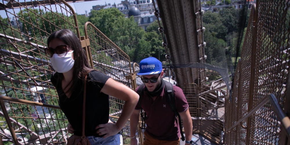 Touristen steigen eine Treppe des Eiffelturms empor. Nach einer über dreimonatigen Zwangspause wegen der Corona-Krise hat der Pariser Eiffelturm am Donnerstag seine Pforten wieder geöffnet. Besucher können zunächst nur über die Treppen den zweiten...