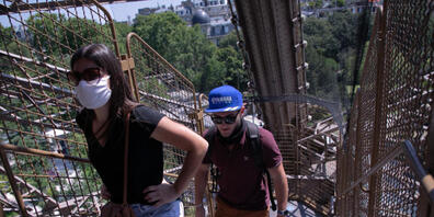 Touristen steigen eine Treppe des Eiffelturms empor. Nach einer über dreimonatigen Zwangspause wegen der Corona-Krise hat der Pariser Eiffelturm am Donnerstag seine Pforten wieder geöffnet. Besucher können zunächst nur über die Treppen den zweiten...