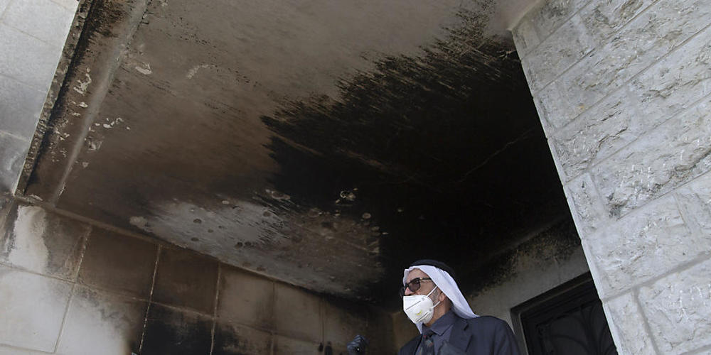 Ein Palästinenser mit Mundschutz inspiziert die verbrannten Mauern der Moschee. Foto: Nasser Nasser/AP/dpa