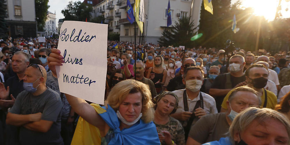 Demonstranten schwenken vor dem Büro des Präsidenten ukrainische Flaggen und halten Plakate mit der Aufschrift: «Soldier Lives Matter». Foto: Efrem Lukatsky/AP/dpa