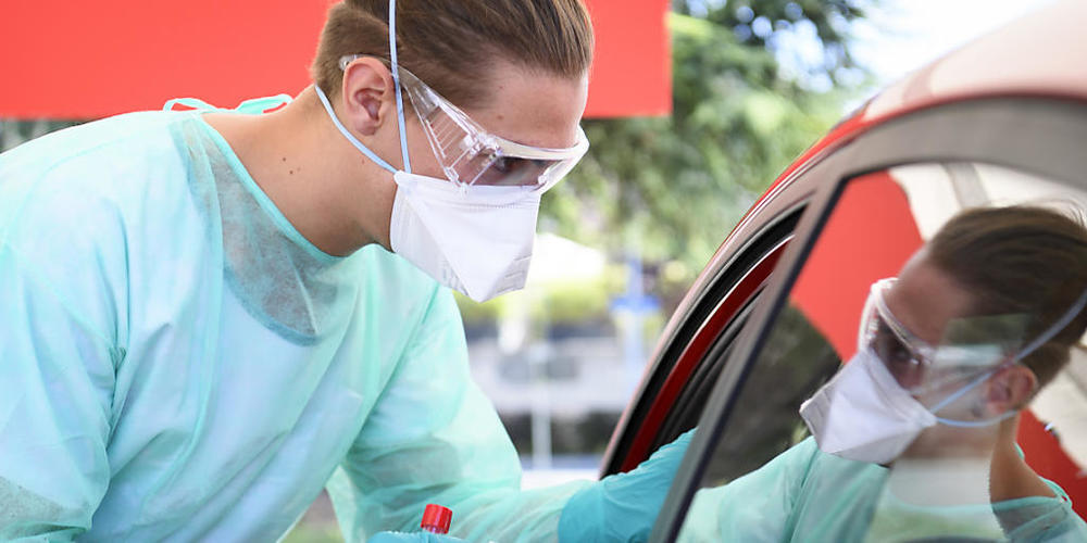 Ein Gesundheitsmitarbeiter in Yverdon-les-Bains VD sammelt in einem Coronavirus-Testzentrum einen Mundabstrich ein. (Archivbild)
