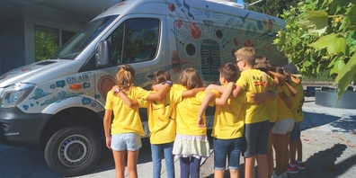 Teilnehmende Kinder und Jugendliche vor dem Radiobus von Power up.