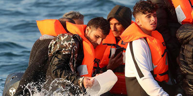 ARCHIV - Eine Gruppe von mutmaßlichen Migranten überquert den Ärmelkanal in einem kleinen Boot in Richtung Dover. Foto: Gareth Fuller/PA Media/dpa