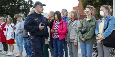 Ein Polizist bittet Demonstrantinnen in Minsk, den Ort zu verlassen. Foto: Dmitri Lovetsky/AP/dpa