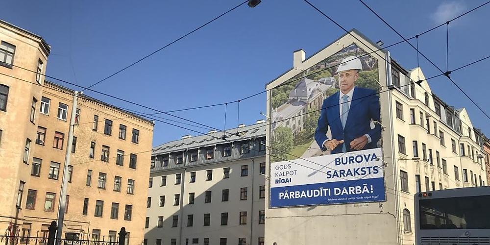 Ein Wahlplakat der Partei "Gods kalpot Rigai" (Es ist eine Ehre Riga zu dienen) mit einem Porträt des bisherigen Bürgermeisters Olegs Burovs hängt an einer Hauswand in der lettischen Hauptstadt Riga. Foto: Alexander Welscher/dpa