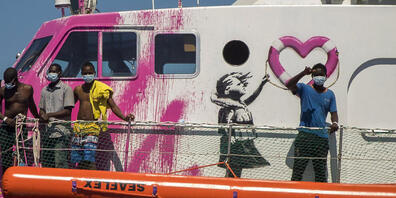dpatopbilder - Ein Junge an Bord der «Louise Michel», das von Banksy finanziert wird, winkt. Foto: Santi Palacios/AP/dpa