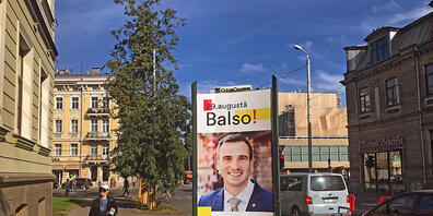Ein Wahlplakat der gemeinsam antretenden liberalen Parteien Für die Entwicklung / Dafür! und Progressive mit einem Porträt ihres Bürgermeisterkandidaten Martins Stakis steht in der Hauptstadt. Foto: Alexander Welscher/dpa - ACHTUNG: Nur zur redakt...