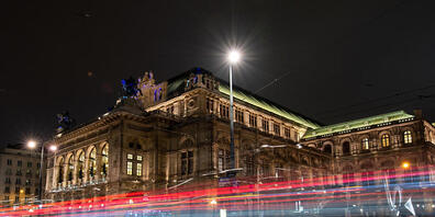 ARCHIV - Die Lichter vorbeifahrender Autos sind vor der Wiener Staatsoper am Abend zu sehen (Langzeitbelichtung). Die Wiener Staatsoper wird am 7. September mit der Premiere von «Madama Butterfly» ihren seit sechs Monaten wegen der Corona-Krise un...