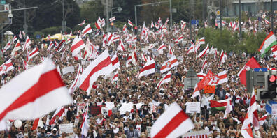 Demonstranten nehmen an einer Kundgebung der Opposition teil und schwenken die historische Nationalflagge des Landes. Trotz eindringlicher Warnungen vor neuen Protesten gegen Staatschef Lukaschenko sind wieder Tausende Menschen in der Hauptstadt M...