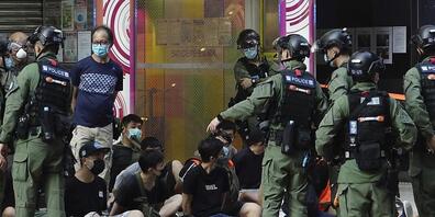 Polizisten nehmen Demonstranten (M) fest. Nach der umstrittenen Verschiebung der Wahl um ein Jahr hatte die Opposition in der chinesischen Sonderverwaltungszone für Sonntag zu Protesten aufgerufen. Foto: Vincent Yu/AP/dpa